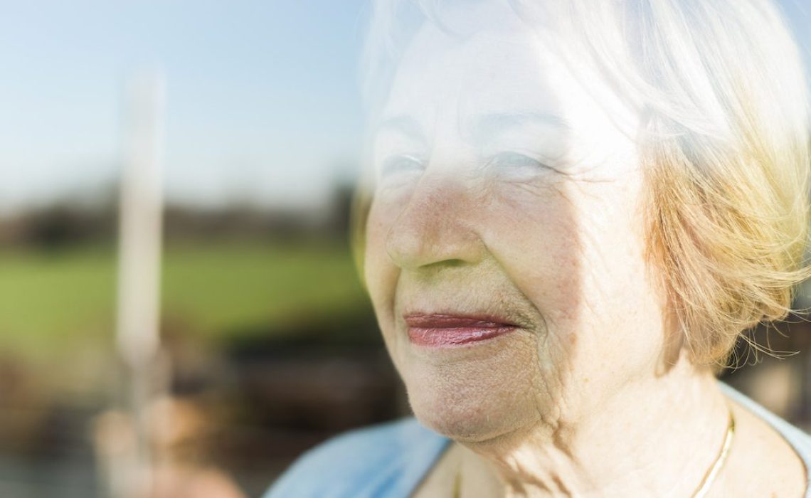 Portrait of senior woman behind windowpane